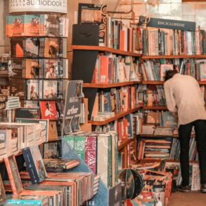 A person browses a vibrant selection of books in a cozy Brașov bookstore.