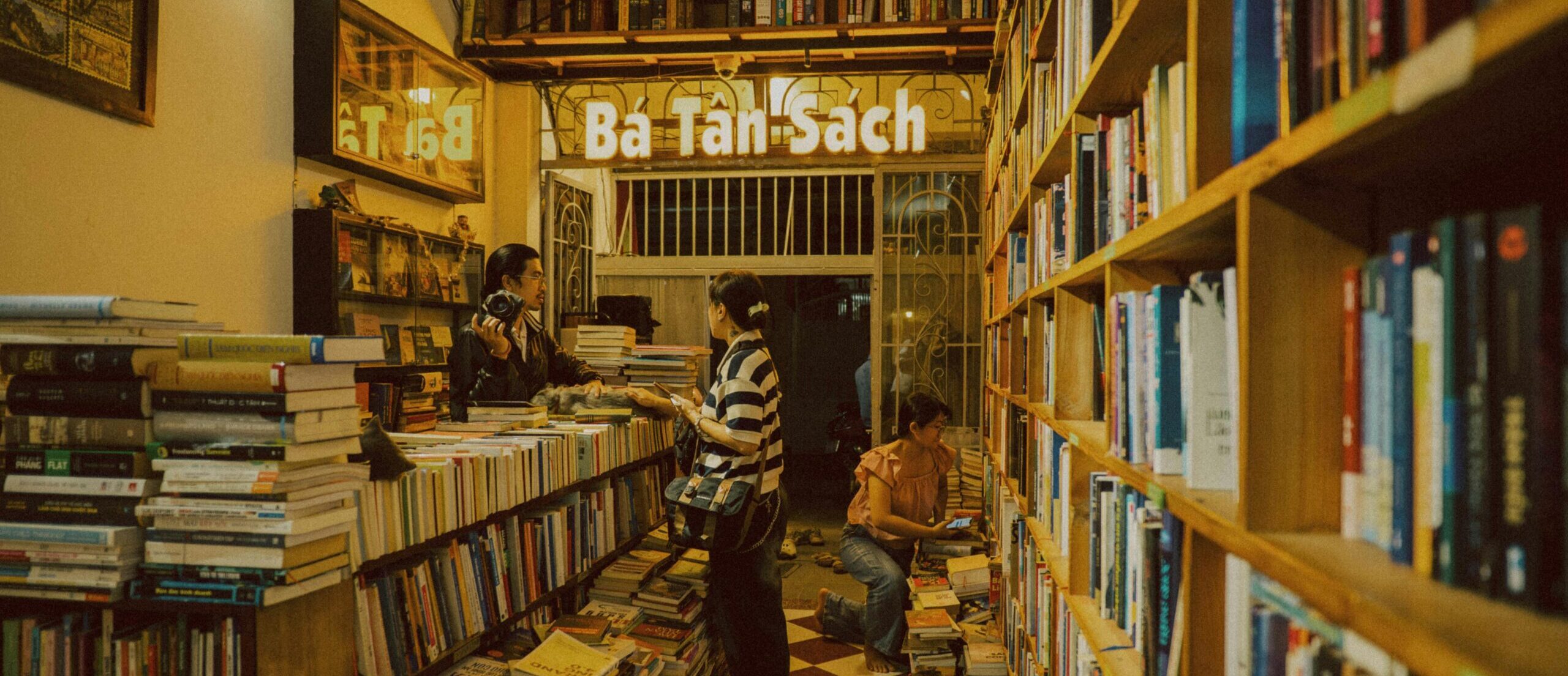 Warm, inviting bookstore with customers browsing books in a quaint indoor setting.